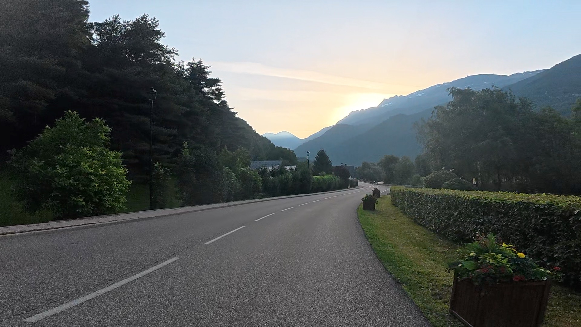 Long empty road out of Bourg d'Oisans with Alpes in distance. Horsham Cycling.